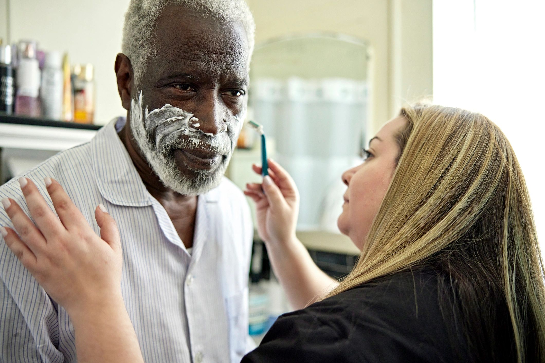 Personal Support Worker assisting a senior client with grooming at home