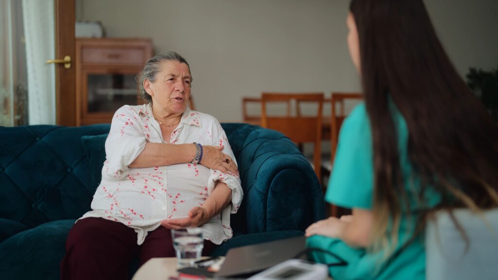 Female doctor visiting her elderly patient at her house for medical check