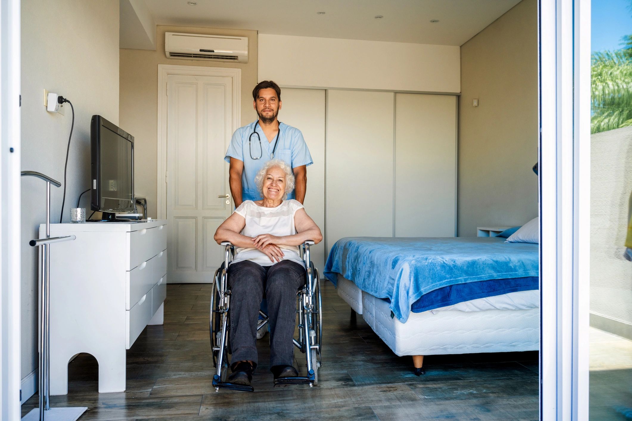 Caregiver assisting senior woman in wheelchair